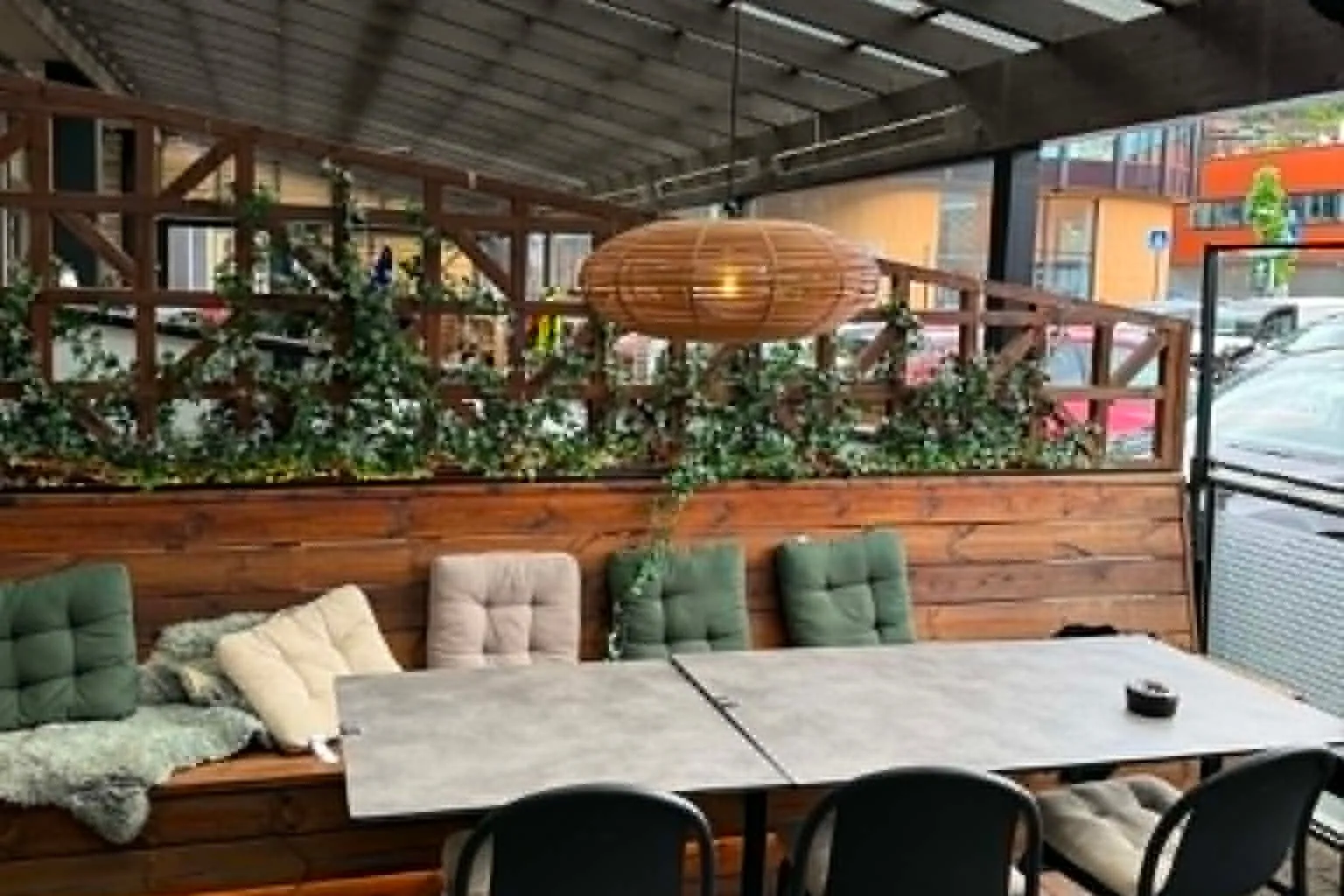 The covered terrace with a wooden bench, cushions and a heat lamp.
